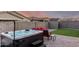 Private backyard area with a hot tub, red outdoor seating, pavers, artificial turf and block wall at 19531 W Palo Verde Dr, Litchfield Park, AZ 85340