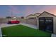 Green backyard with a hot tub, patio seating, artificial grass, and a convenient storage shed at 19531 W Palo Verde Dr, Litchfield Park, AZ 85340