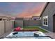 Relaxing backyard with a hot tub, artificial grass, and a convenient storage shed at 19531 W Palo Verde Dr, Litchfield Park, AZ 85340