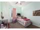 Bright bedroom features a ceiling fan, window, and twin bed with storage underneath at 19531 W Palo Verde Dr, Litchfield Park, AZ 85340