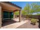 A covered patio leads to a gravel backyard with desert landscaping and block wall for privacy at 1965 N 213Th Dr, Buckeye, AZ 85396
