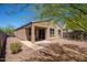 A covered patio sits in a xeriscaped backyard, providing a shaded outdoor living space at 1965 N 213Th Dr, Buckeye, AZ 85396