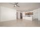 Open-concept living space with tile flooring, ceiling fan, and kitchen island in the background at 1965 N 213Th Dr, Buckeye, AZ 85396