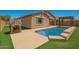 Private backyard with a sparkling pool, playhouse, and artificial grass for easy maintenance at 19889 W Sherman St, Buckeye, AZ 85326