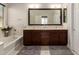 Well-lit bathroom with dual sinks, dark wood cabinets, soaking tub, and stylish fixtures at 19889 W Sherman St, Buckeye, AZ 85326