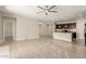 Open-concept living room featuring tile flooring, neutral paint, ceiling fan, and a kitchen island with pendant lighting at 19889 W Sherman St, Buckeye, AZ 85326