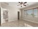 Main bedroom featuring tile flooring, neutral paint, ceiling fan, and ensuite bath at 19889 W Sherman St, Buckeye, AZ 85326