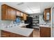 Traditional kitchen featuring wood cabinets, laminate countertops, and a black refrigerator, offering a practical cooking space at 212 Leisure World --, Mesa, AZ 85206