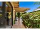 Covered patio featuring tiled flooring, outdoor seating, and lush greenery, offering a secluded space for relaxation and enjoyment at 212 Leisure World --, Mesa, AZ 85206