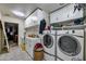 Functional laundry room featuring white cabinetry, washer, dryer, utility sink, and a tiled floor at 22201 E Vallejo St, Queen Creek, AZ 85142
