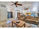 Spacious living room boasts a large window, ceiling fan, and flows into the kitchen at 22201 E Vallejo St, Queen Creek, AZ 85142