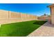 Low-maintenance backyard with an artificial lawn, high block wall, and stylish hardscape, offering privacy at 27713 N 57Th Dr, Phoenix, AZ 85083