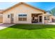 Charming backyard with artificial lawn, covered patio, and neutral tones, providing a perfect outdoor setting at 27713 N 57Th Dr, Phoenix, AZ 85083
