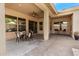 Covered patio with stylish furniture, neutral color palette, and an inviting space for outdoor relaxation at 27713 N 57Th Dr, Phoenix, AZ 85083