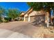 View of the home's front and three-car garage, showcasing its inviting facade at 27713 N 57Th Dr, Phoenix, AZ 85083
