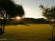Expansive green space with mature trees and scenic mountain views at sunset at 27713 N 57Th Dr, Phoenix, AZ 85083