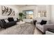 Inviting living room with stylish gray sofa, textured rug, bright window, and tasteful decor at 27713 N 57Th Dr, Phoenix, AZ 85083