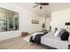 Bright primary bedroom with light wood floors and a large window offering outdoor views at 27713 N 57Th Dr, Phoenix, AZ 85083