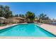 Image showing community pool surrounded by lounge chairs, a shaded area, and green trees at 319 N Riata St, Gilbert, AZ 85234