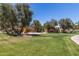 A well-maintained playground with a slide and swings is framed by mature trees and lush green lawns at 319 N Riata St, Gilbert, AZ 85234