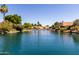 Scenic waterfront view of a calm canal lined with houses with terra cotta roofs and lush green landscaping at 319 N Riata St, Gilbert, AZ 85234