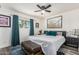 Cozy bedroom with a ceiling fan, picture window, teal drapes and a large picture above the bed at 325 E Harmony Ave, Mesa, AZ 85210