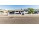 Charming single-story home with a gray exterior, red door, and a modern white brick and black horizontal slat fence at 325 E Harmony Ave, Mesa, AZ 85210