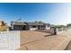 View of house with covered parking area, front yard landscaping and white brick accent wall with horizontal black slat fence at 325 E Harmony Ave, Mesa, AZ 85210