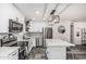 Modern kitchen with stainless steel appliances, stylish lighting, white cabinetry, large island and a view to the entry hallway at 325 E Harmony Ave, Mesa, AZ 85210