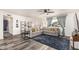 Open-concept living room featuring modern decor, gray sectional, stylish shelving and gray toned hard wood flooring at 325 E Harmony Ave, Mesa, AZ 85210