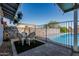Seating area on patio near a refreshing in-ground swimming pool and privacy fence at 325 E Harmony Ave, Mesa, AZ 85210