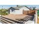 Side yard featuring desert landscaping, a modern white brick and horizontal wood slat fence and mature trees at 325 E Harmony Ave, Mesa, AZ 85210