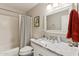 Bathroom with white vanity featuring granite countertop, framed mirror, and shower with striped curtain at 3505 S Westfall Ave, Tempe, AZ 85282