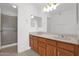 Bathroom with double sink vanity, wooden cabinets, large mirror and walk-in shower with sliding glass door at 3510 E Hampton Ave # 18, Mesa, AZ 85204
