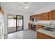 Open kitchen with oak cabinets, white appliances, and sliding doors to the patio at 3510 E Hampton Ave # 18, Mesa, AZ 85204