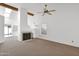 Bright living room featuring a fireplace, ceiling fan, skylight, and neutral carpet at 3510 E Hampton Ave # 18, Mesa, AZ 85204