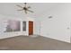 Bright, open living room with a ceiling fan, neutral carpeting, and a view of the outdoors at 3510 E Hampton Ave # 18, Mesa, AZ 85204