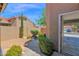 View of the home's side yard, landscaped with mature plants, a concrete walkway, and a privacy fence at 3510 E Hampton Ave # 18, Mesa, AZ 85204