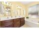 Well-lit bathroom with dual sinks, a soaking tub, and elegant fixtures, creating a relaxing and functional space at 3534 E Linda Ln, Gilbert, AZ 85234