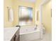 Bathroom featuring a soaking tub with a large window, a toilet, and vanity with dark wood cabinets at 3534 E Linda Ln, Gilbert, AZ 85234