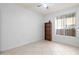 A simple bedroom with white walls, tile flooring, a window, and a wooden shelf at 3534 E Linda Ln, Gilbert, AZ 85234