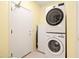 Clean laundry room with a stacked washer and dryer, tile flooring, and a white door at 3534 E Linda Ln, Gilbert, AZ 85234