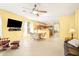 Open-concept living space with tiled flooring, a ceiling fan, and seamless flow into the kitchen and dining areas at 3534 E Linda Ln, Gilbert, AZ 85234