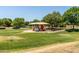 Community playground features a covered play structure and accessible ramp surrounded by a grassy lawn at 3534 E Linda Ln, Gilbert, AZ 85234