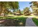 Community playground with multiple covered play areas and a walking path amidst lush greenery and mature trees at 3534 E Linda Ln, Gilbert, AZ 85234