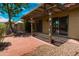 View of the covered brick patio surrounded by mature shade tree and lush landscaping at 4225 E Sandia St, Phoenix, AZ 85044