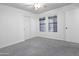 This bedroom has gray carpet, a ceiling fan, and two windows at 4225 E Sandia St, Phoenix, AZ 85044