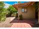 Side view of home with brick paved patio, desert landscaping and beige stucco exterior with a window reflection at 4225 E Sandia St, Phoenix, AZ 85044
