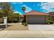 Charming single-story home with a tile roof, two-car garage, and desert landscaping under a partly cloudy blue sky at 4225 E Sandia St, Phoenix, AZ 85044