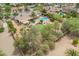 An aerial shot of the property featuring a pool, lawn, trees, and an outdoor entertainment area at 6102 E Aster Dr, Scottsdale, AZ 85254